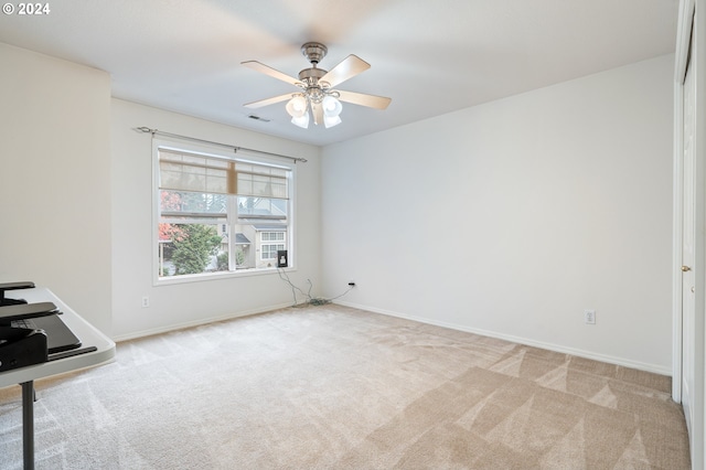 carpeted spare room with ceiling fan