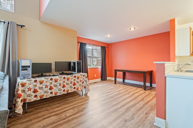 bedroom featuring sink and light hardwood / wood-style floors