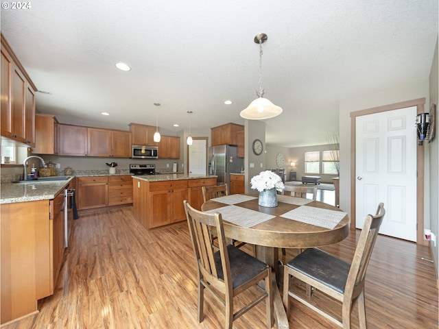 dining area featuring sink, a textured ceiling, and light hardwood / wood-style flooring