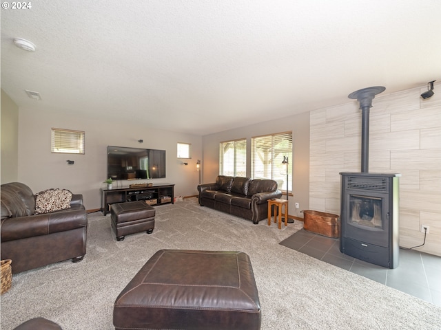 carpeted living room with a wood stove and a textured ceiling