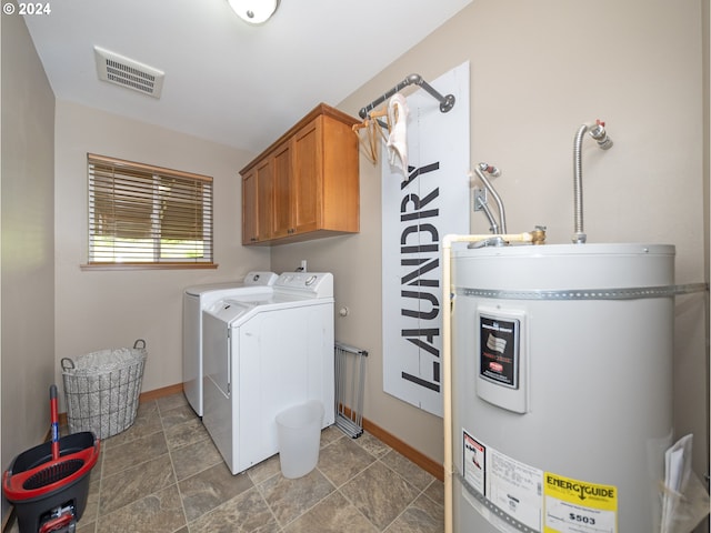 clothes washing area featuring strapped water heater, cabinets, and washing machine and clothes dryer