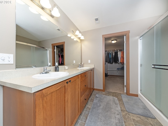 bathroom with vaulted ceiling, vanity, and a shower with door