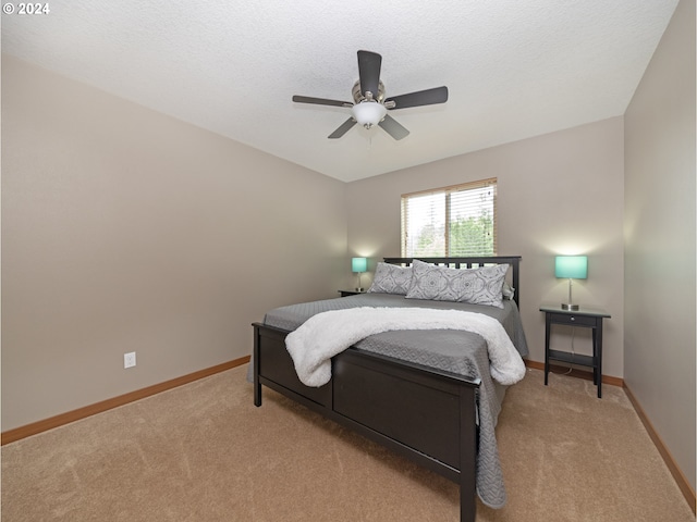 bedroom featuring light carpet, a textured ceiling, and ceiling fan