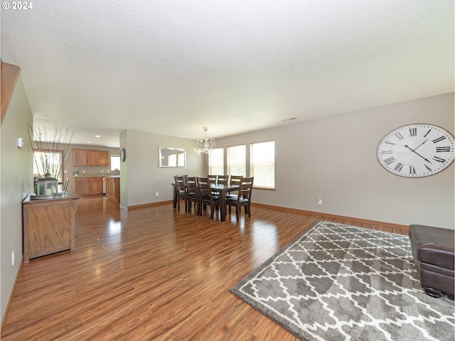 dining room featuring an inviting chandelier, wood-type flooring, and a textured ceiling