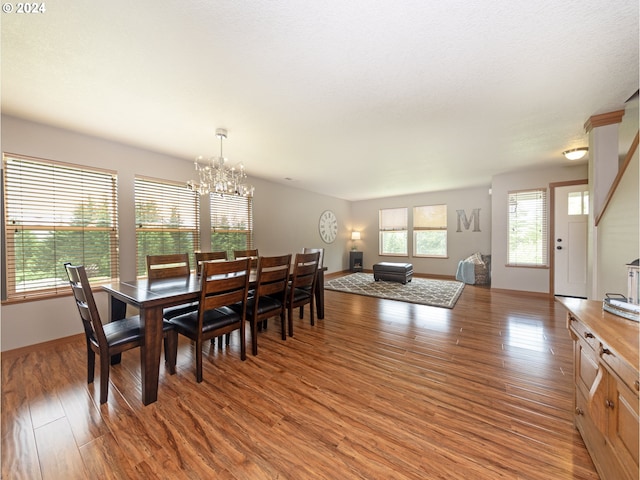 dining space with hardwood / wood-style floors and a chandelier