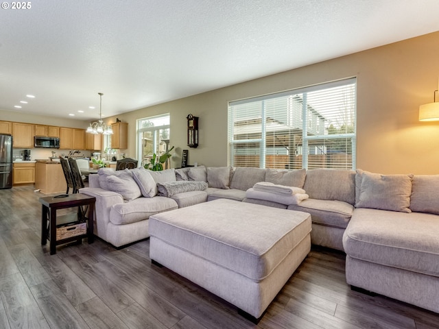 living room featuring dark hardwood / wood-style flooring and an inviting chandelier