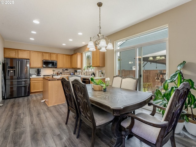 dining room with hardwood / wood-style floors and a chandelier