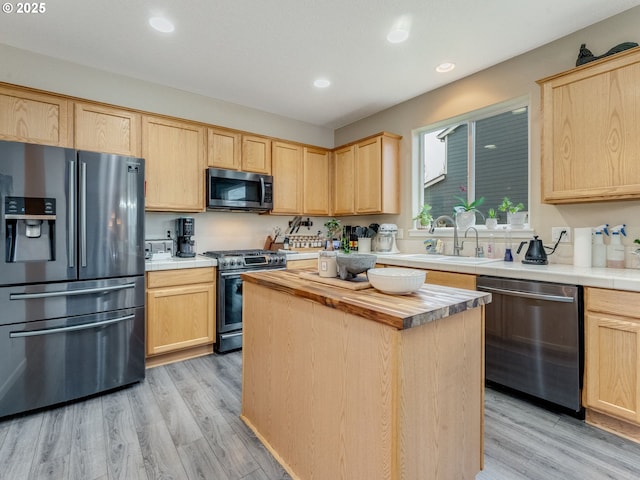 kitchen featuring wood counters, light brown cabinetry, sink, and stainless steel appliances