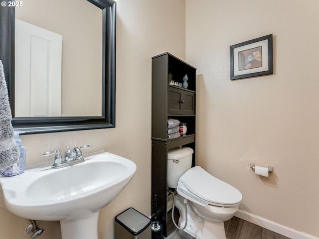 bathroom featuring toilet, wood-type flooring, and sink