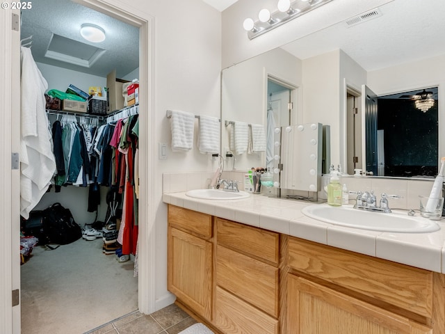 bathroom featuring a textured ceiling, vanity, and tile patterned flooring