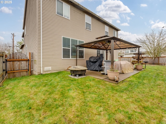 rear view of house featuring a patio area, a gazebo, a fire pit, and a lawn