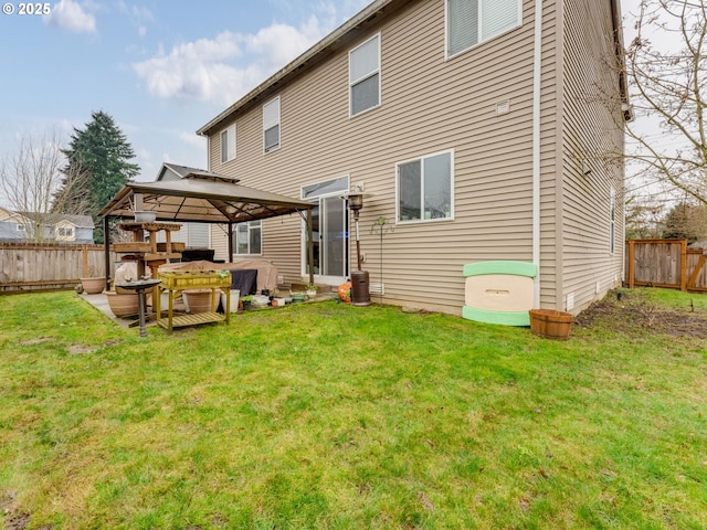 rear view of house with a lawn and a gazebo