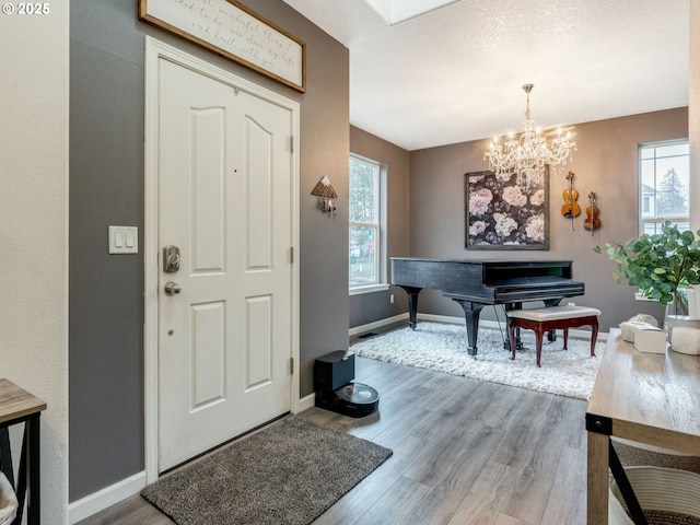 foyer entrance featuring wood-type flooring and a notable chandelier