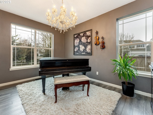 misc room with dark hardwood / wood-style floors, a notable chandelier, and a healthy amount of sunlight