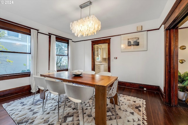 dining room featuring a notable chandelier and dark wood-type flooring