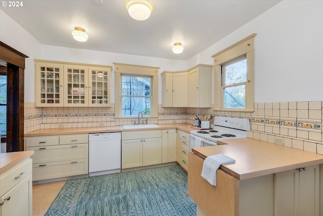 kitchen featuring plenty of natural light, sink, white appliances, and cream cabinetry