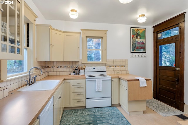 kitchen featuring white appliances, sink, tasteful backsplash, cream cabinetry, and light tile patterned flooring