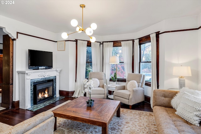 living room with a premium fireplace, hardwood / wood-style floors, and an inviting chandelier