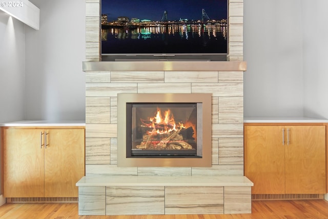 room details with a tiled fireplace and wood finished floors