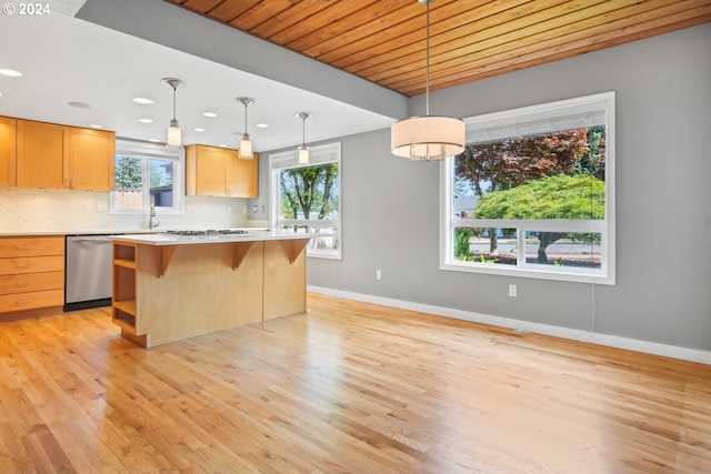 kitchen featuring a kitchen island, stainless steel appliances, light countertops, a kitchen bar, and pendant lighting