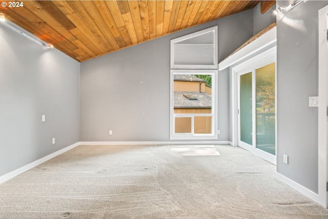 carpeted empty room with lofted ceiling, wood ceiling, and baseboards