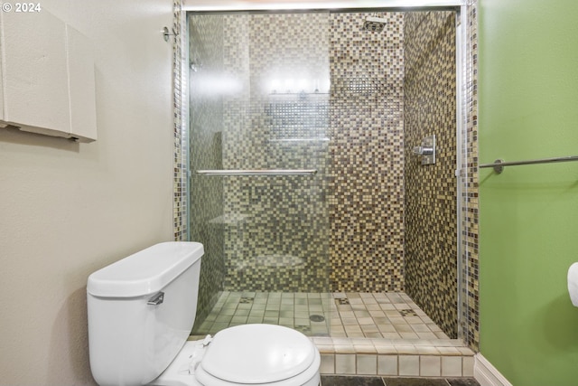 bathroom featuring toilet and a stall shower