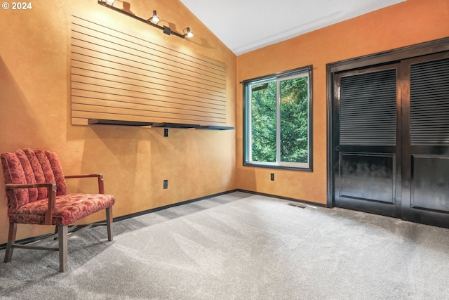 unfurnished room with lofted ceiling, baseboards, and light colored carpet