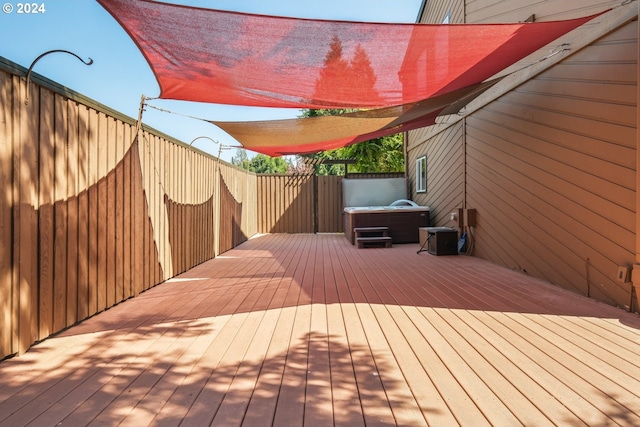 wooden deck with a fenced backyard and a hot tub