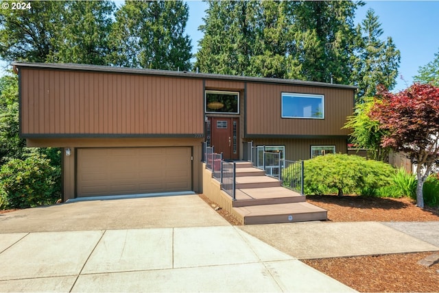 raised ranch with a garage and concrete driveway