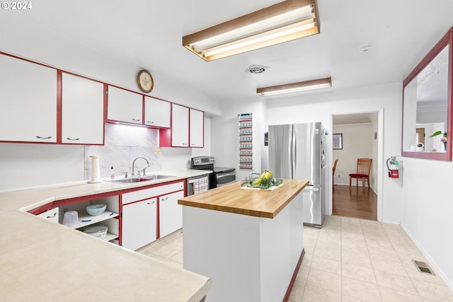 kitchen featuring light tile patterned floors, visible vents, a sink, decorative backsplash, and stainless steel appliances