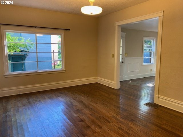 unfurnished room featuring a textured ceiling and dark hardwood / wood-style flooring