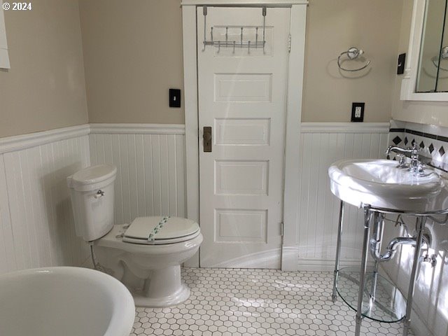 bathroom with tile patterned flooring, a bathtub, toilet, and sink