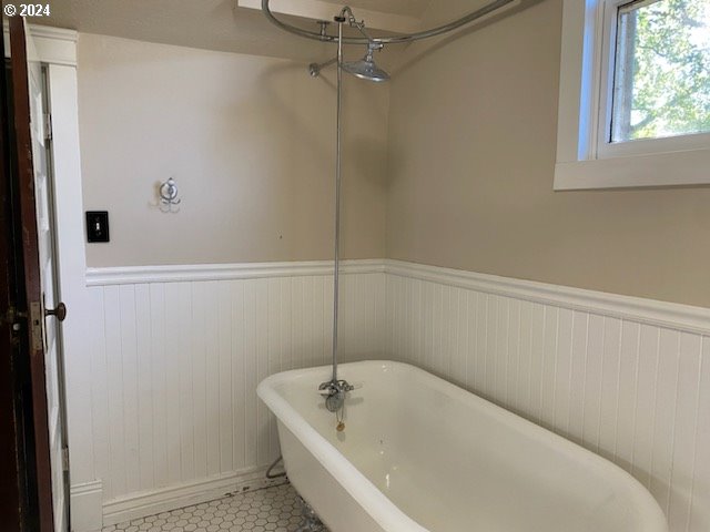 bathroom with tile patterned floors and a tub