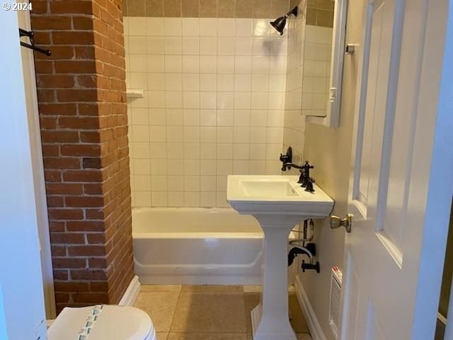 bathroom featuring tile patterned floors, tiled shower / bath combo, and toilet