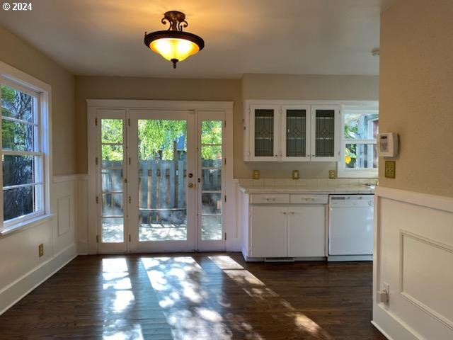 doorway with dark wood-type flooring and a healthy amount of sunlight