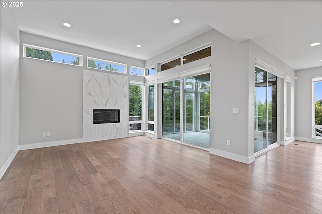 13560 SW Whitworth Ct, Beaverton, OR 97005 - unfurnished living room featuring recessed lighting, hardwood / wood-style flooring, plenty of natural light, and a premium fireplace