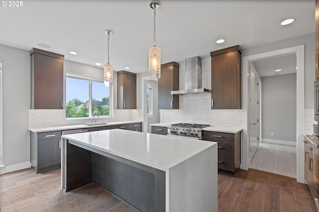 13560 SW Whitworth Ct, Beaverton, OR 97005 - kitchen featuring wall chimney range hood, a sink, decorative backsplash, dark brown cabinetry, and baseboards