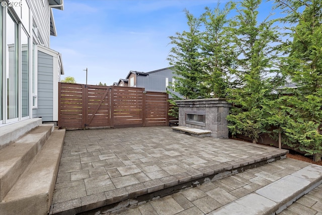 13560 SW Whitworth Ct, Beaverton, OR 97005 - view of patio / terrace with an outdoor stone fireplace and a fenced backyard
