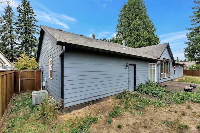 view of property exterior with a patio and central AC