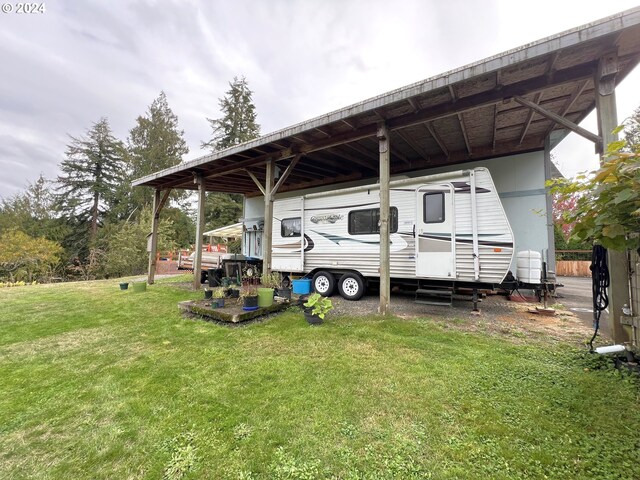 view of vehicle parking with a yard and a carport