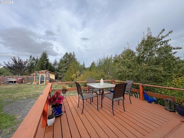 deck featuring a yard and a storage unit