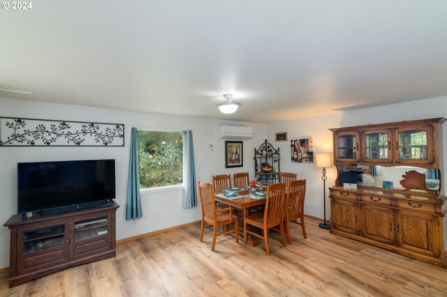 dining room with a wall mounted AC and light wood-type flooring