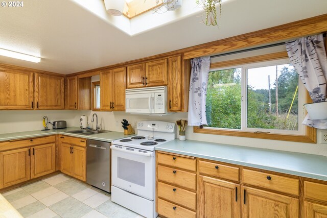 kitchen with white appliances, sink, and light tile patterned floors