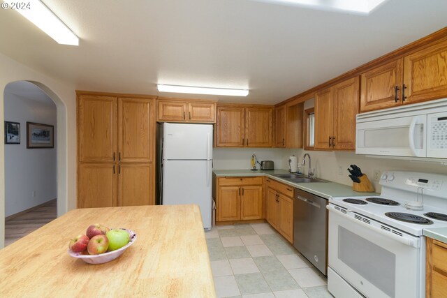 kitchen featuring wood counters, sink, and white appliances