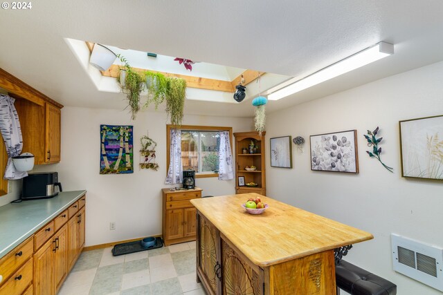 kitchen featuring heating unit, butcher block countertops, a center island, and a breakfast bar