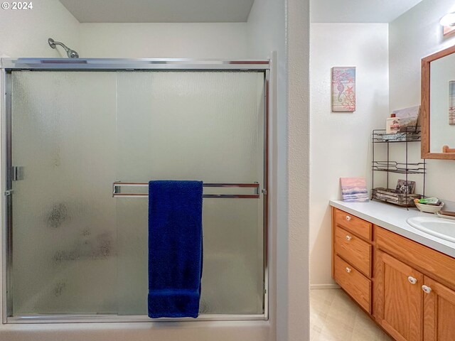 bathroom with vanity and a shower with shower door