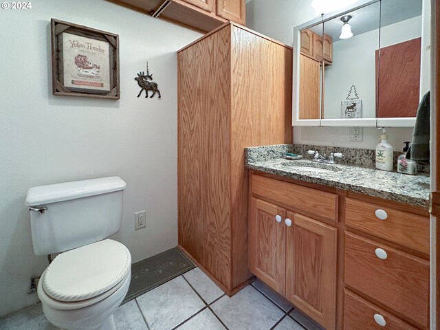 bathroom featuring vanity, tile patterned flooring, and toilet