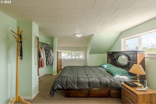 bedroom featuring carpet, multiple windows, and lofted ceiling