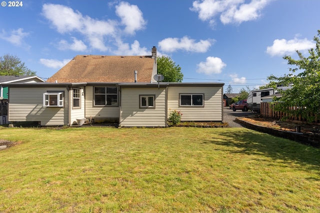 rear view of property with a lawn