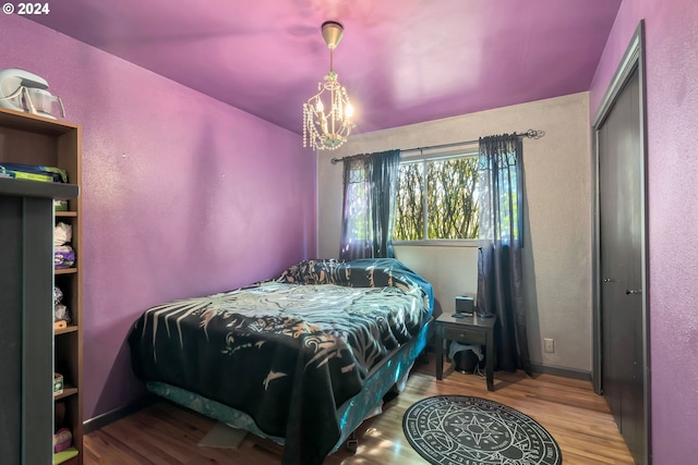 bedroom with a notable chandelier, a closet, and wood-type flooring